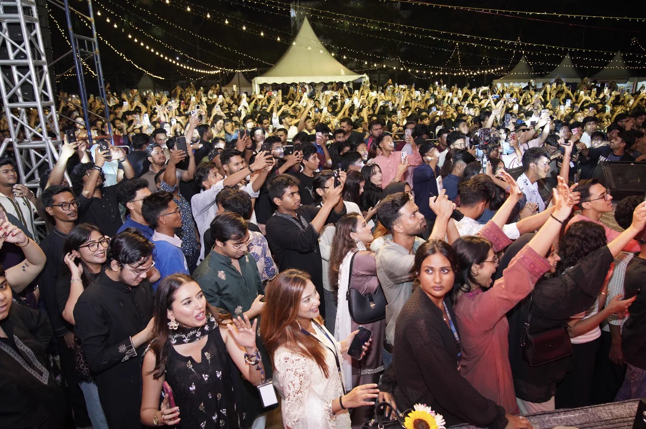 Eid-E-Bahar audience members filming and celebrating beneath festival lights
