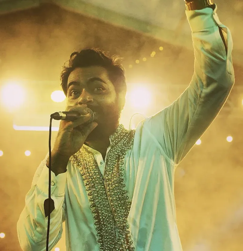 Eid-E-Bahar vocalist performing under warm stage lighting